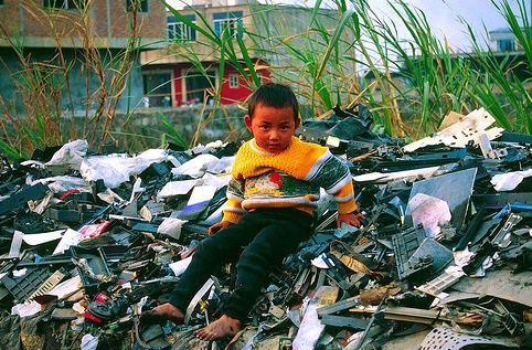 Niño entre los desechos de ordenadores